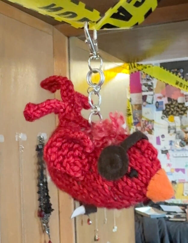 Knit bird with felt, chainmail, and shrink plastic details.